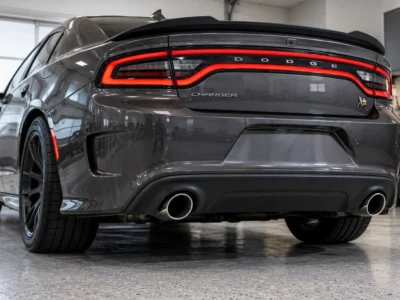 Rear of a dark grey Dodge Charger Scat Pack with the factory exhaust tips in the lower valance