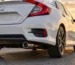 Rear of a white Honda Civic sedan with a polished resonated exhaust tip under the bumper